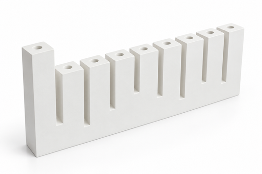 White concrete Hanukkah menorah with nine candle sockets and raised left shamash, angled view