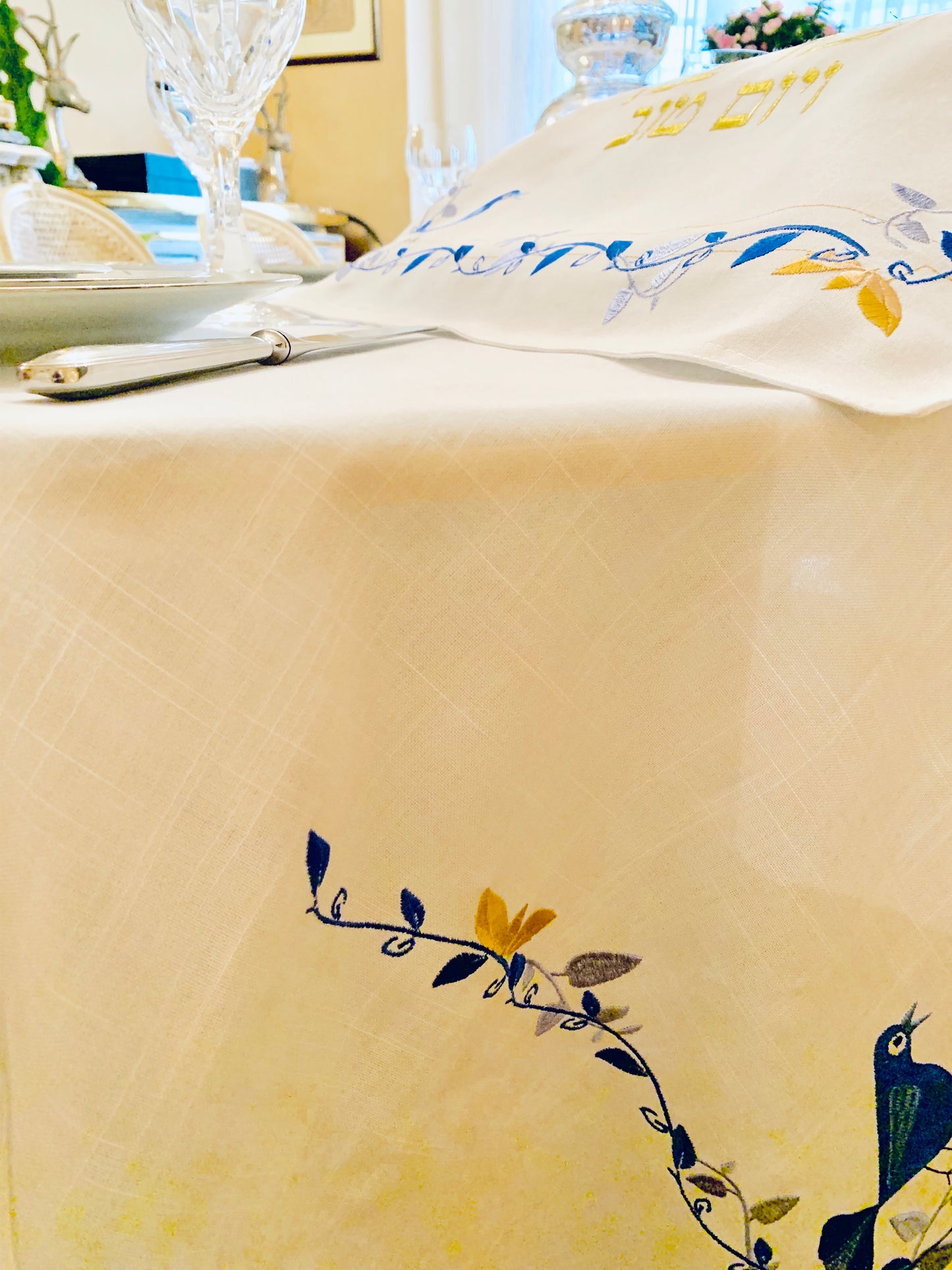 The Blue Bird Tablecloth Embroidered on Pure White Linen. Matching Challah Cover is available