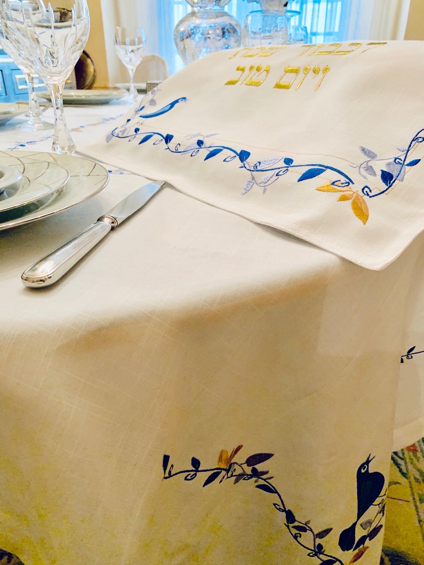 The Blue Bird Tablecloth Embroidered on Pure White Linen. Matching Challah Cover is available