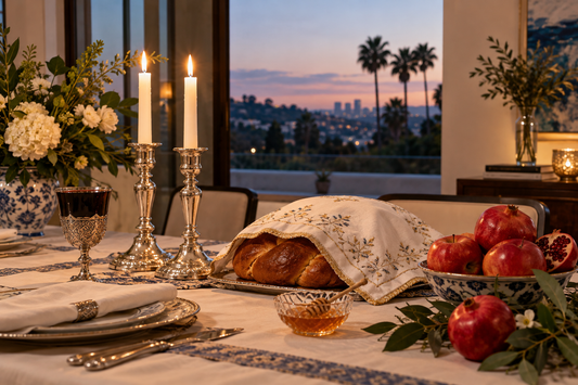 Rosh Hashanah Shabbat table with candles, challah, apples, honey and pomegranates in a Los Angeles home