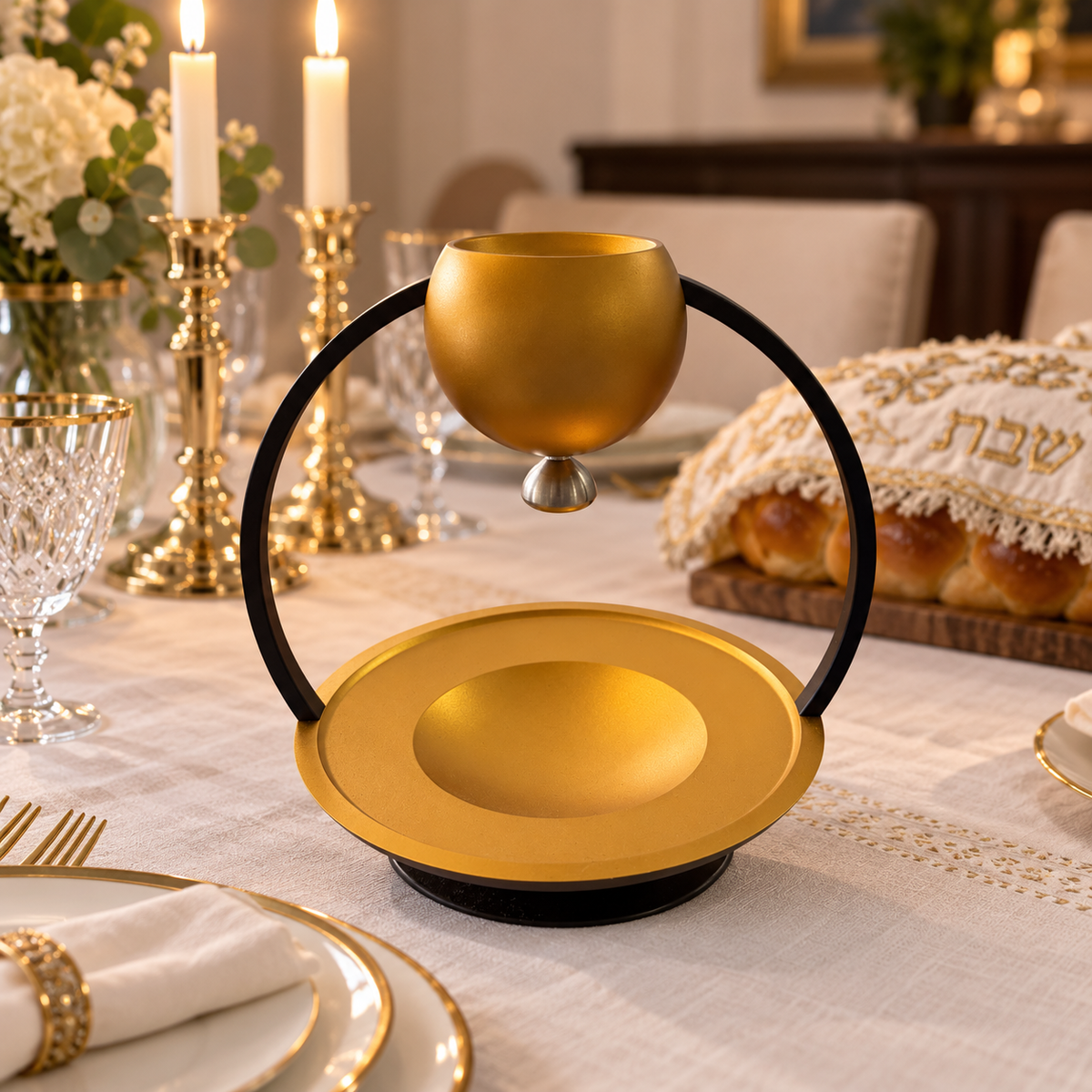 Akilov gold and black mayim acharonim set on an elegant Shabbat table