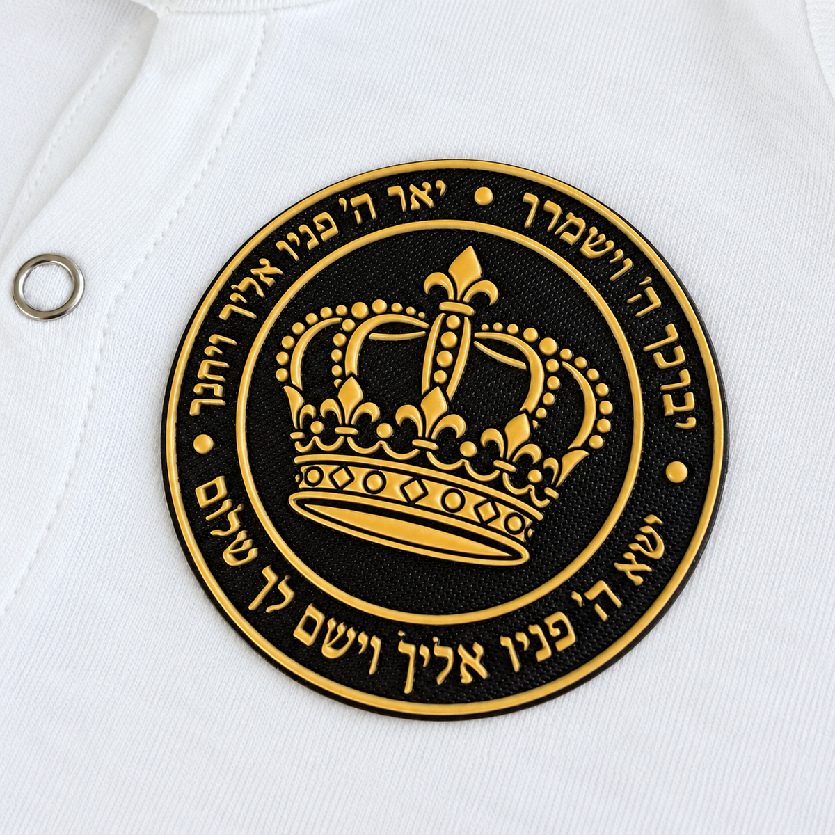 Close-up of the black silicone patch with raised gold crown and Hebrew Birkat Kohanim blessing