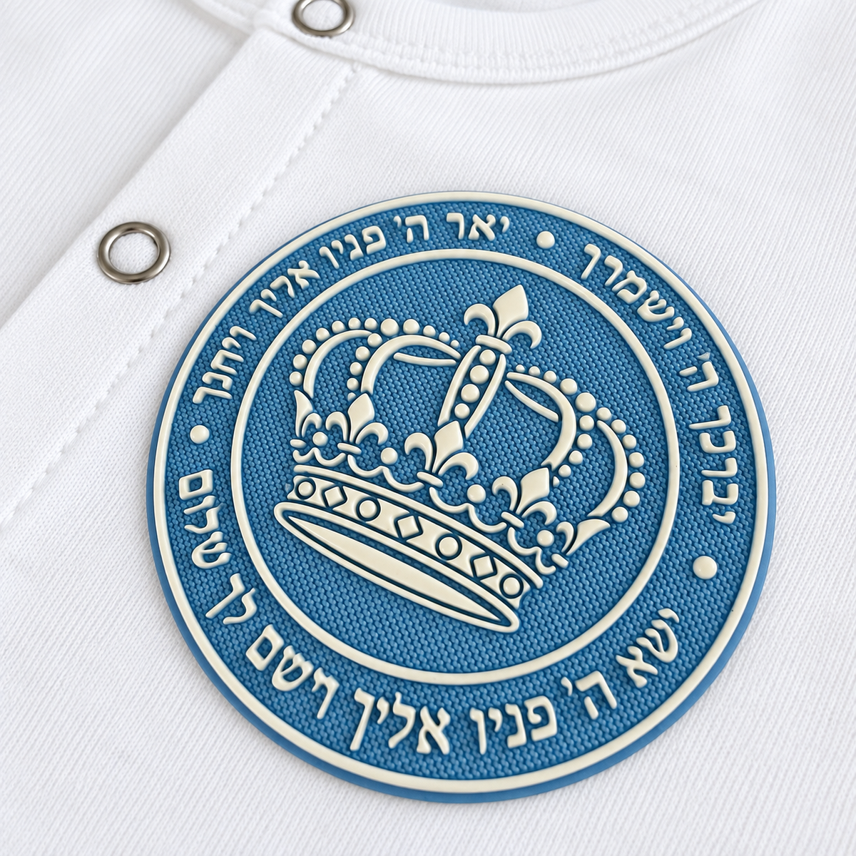 Close-up of the blue silicone patch with ivory crown and Hebrew Birkat Kohanim blessing