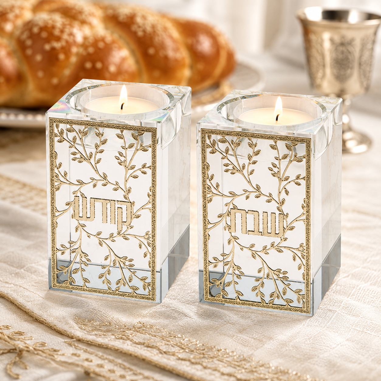 Crystal Shabbat candlestick holders with gold plaques staged on a Shabbat table