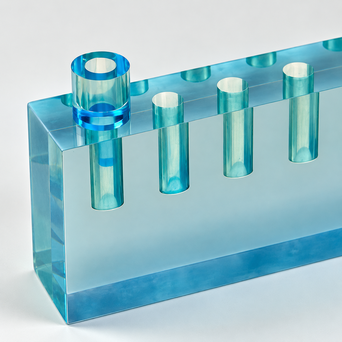 Close-up of the blue lucite menorah showing its raised shamash holder and polished acrylic edges