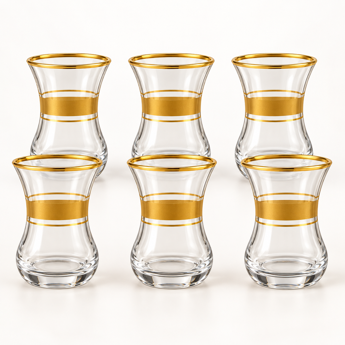 Six clear glass tea cups with gold bands on a white background