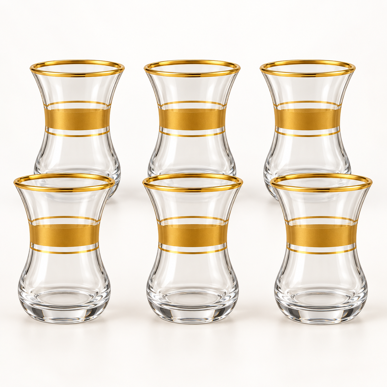 Six clear glass tea cups with gold bands on a white background