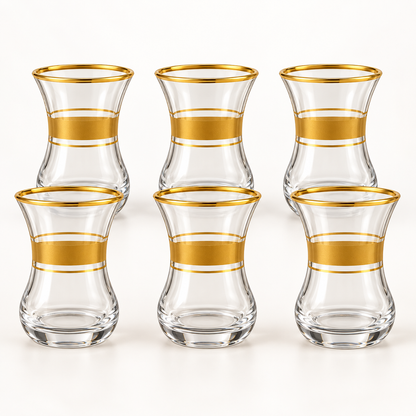 Six clear glass tea cups with gold bands on a white background
