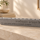 Gray Al Hanissim concrete hanukkiah displayed on a stone console in a neutral home