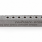 Higher angle of gray Al Hanissim concrete hanukkiah showing nine recessed holders and engraved Hebrew lettering