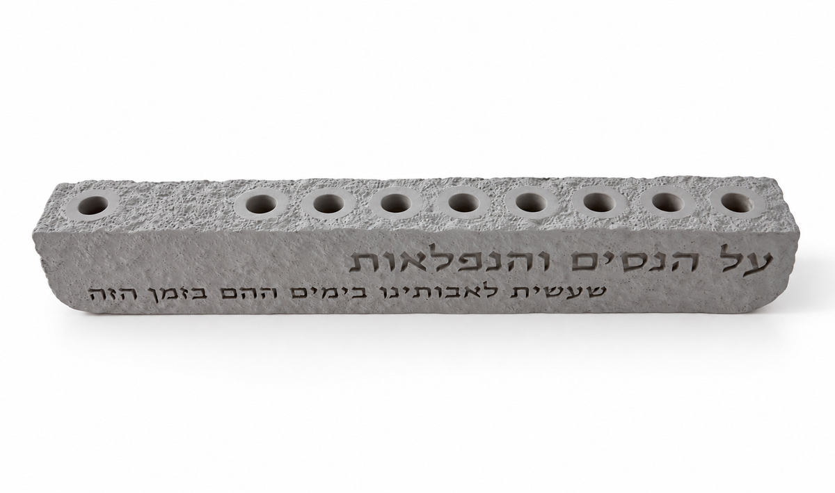 Higher angle of gray Al Hanissim concrete hanukkiah showing nine recessed holders and engraved Hebrew lettering