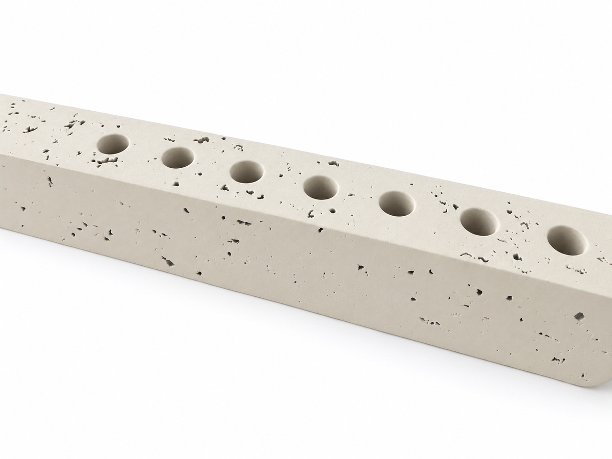 Close-up of ivory concrete hanukkiah showing natural pores and round recessed holders