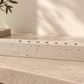 Ivory concrete hanukkiah on a warm stone console in a softly lit modern home