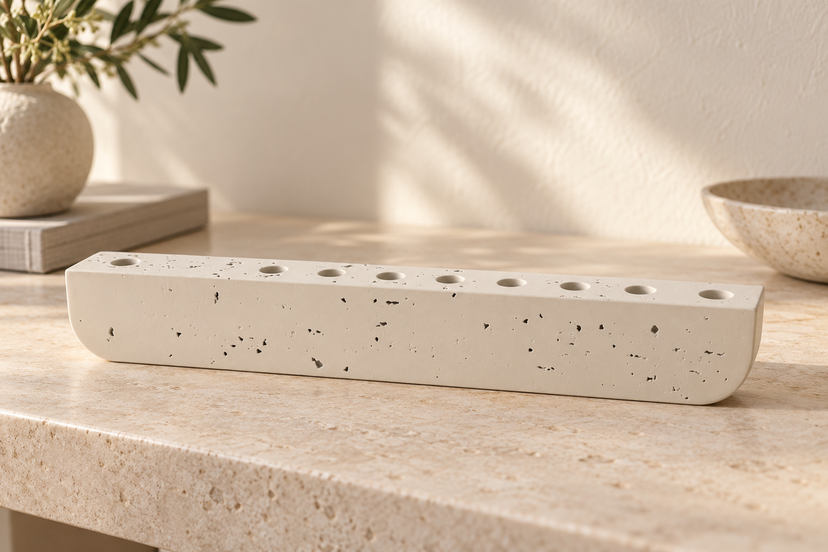 Ivory concrete hanukkiah on a warm stone console in a softly lit modern home