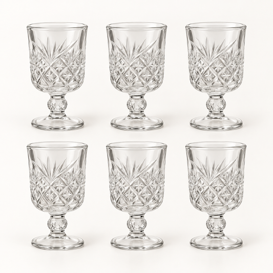 Six mini cut-glass wine goblets on a white background