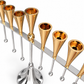Close-up of gold tapered oil-cup holders and gold shamash accent on a silver crossbar with silver hanging rods and balls