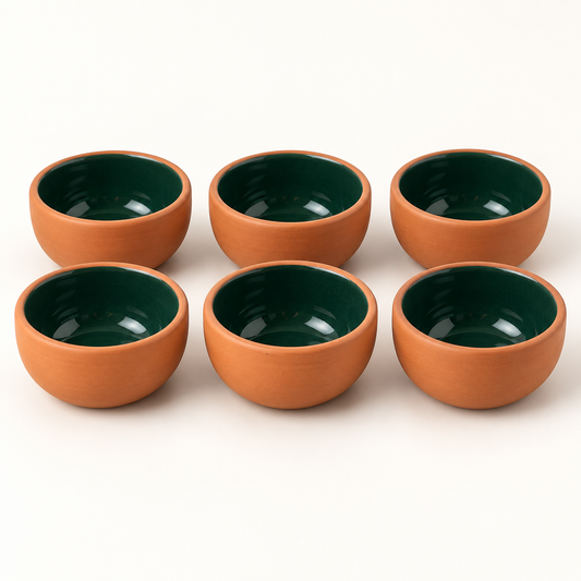 Six terracotta ceramic mini bowls with green interiors on a white background