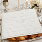 White Western Wall challah cover staged over challah on a Shabbat table