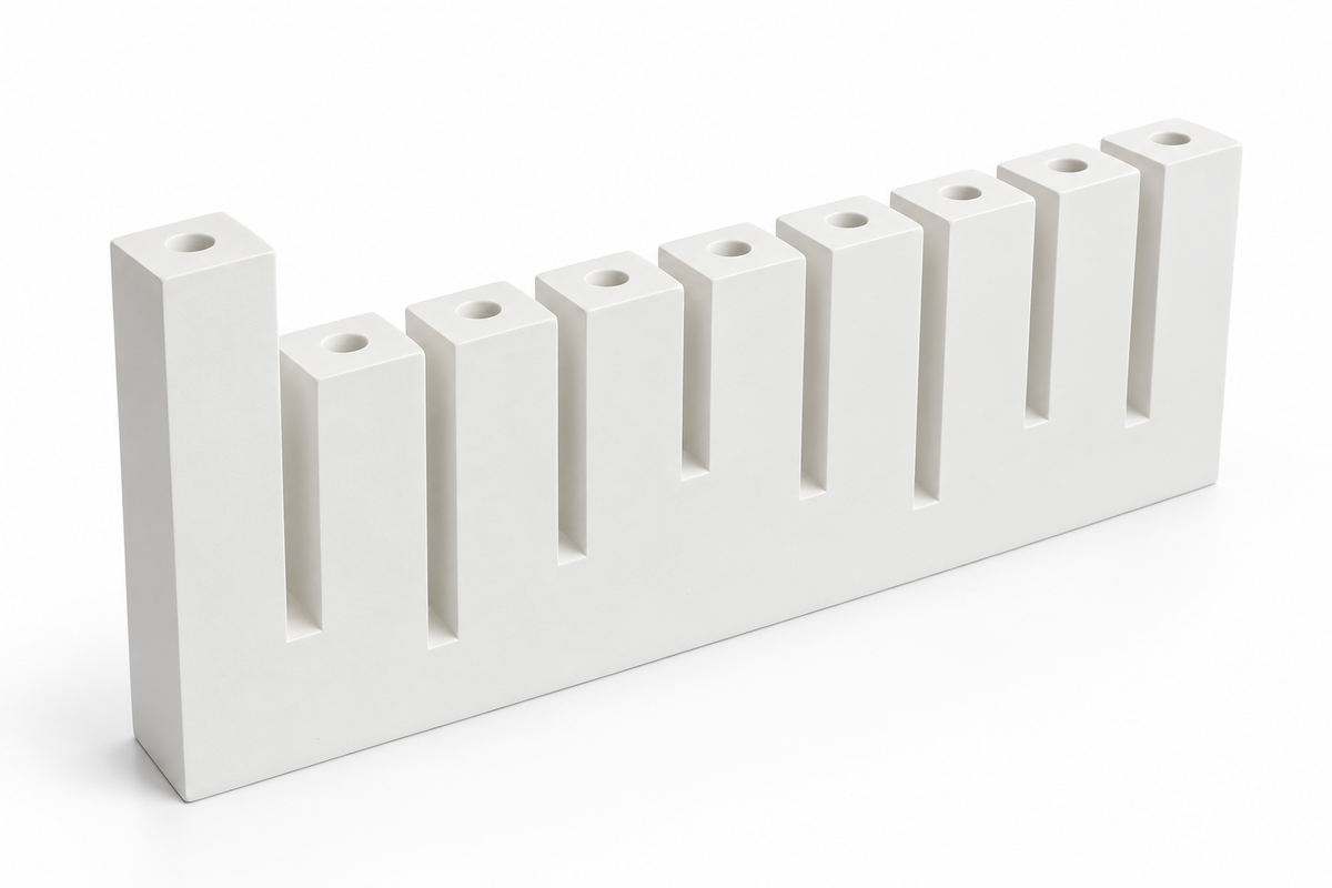 White concrete Hanukkah menorah with nine candle sockets and raised left shamash, angled view