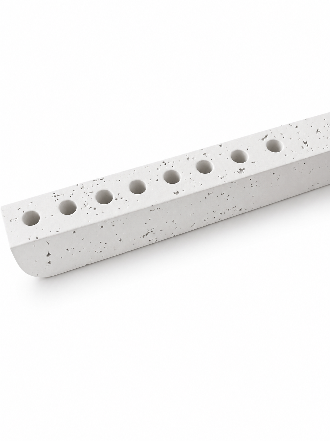 Close-up of white concrete hanukkiah showing subtle textured pores and recessed holders