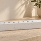 White concrete hanukkiah displayed on a stone console in a softly lit modern home