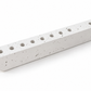 White concrete hanukkiah viewed from above with eight aligned holders and one holder set apart