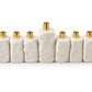 White textured concrete Hanukkah menorah with nine gold-tone holders and a raised center shamash on a white background.